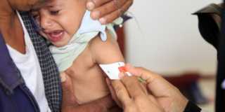 En gråtande liten pojke får sin överarm mätt i Jemen.